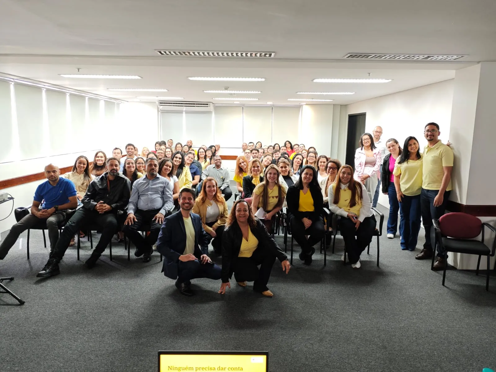 Foto de grupo com dezenas de colaboradores da Hausy, de camiseta amarela, ao fim da palestra de Setembro Amarelo, com Rafael Macedo à frente